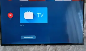 Ekran telewizora z ikonami aplikacji, w tym Netflix i YouTube. Widoczne są czarne paski po bokach.