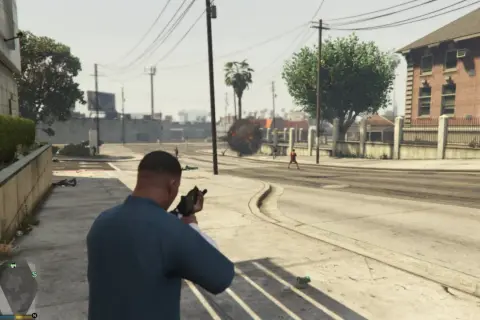 Gracz w GTA V z bronią, w tle wybuch i postacie. Mody GTA 5 dodają akcji!