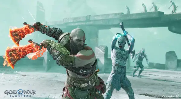 Kratos z płonącymi toporami walczy z lodowym przeciwnikiem. Długość gry God of War Ragnarök to epicka przygoda.