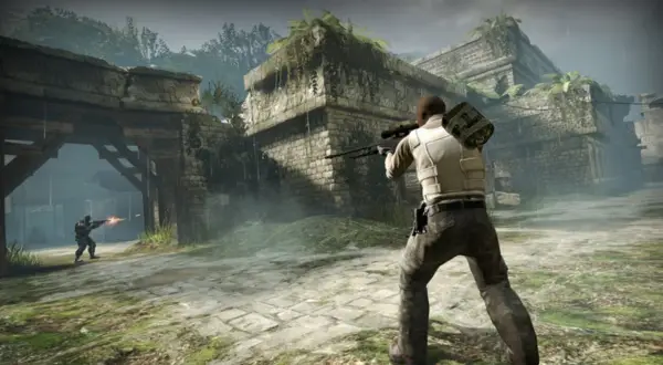 Gracz z karabinem snajperskim w ruinach, gotowy do walki. Dowiedz się, jak włączyć konsolę w CS: GO, by usprawnić rozgrywkę.