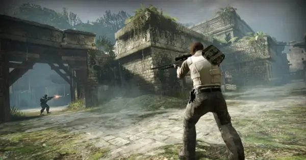 Gracz z karabinem snajperskim w ruinach, gotowy do walki. Dowiedz się, jak włączyć konsolę w CS: GO, by usprawnić rozgrywkę.